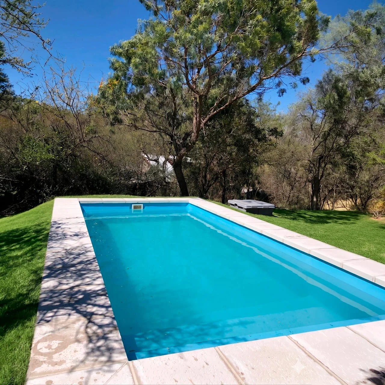 Piscina de fibra de vidrio instalada en un parque arbolado