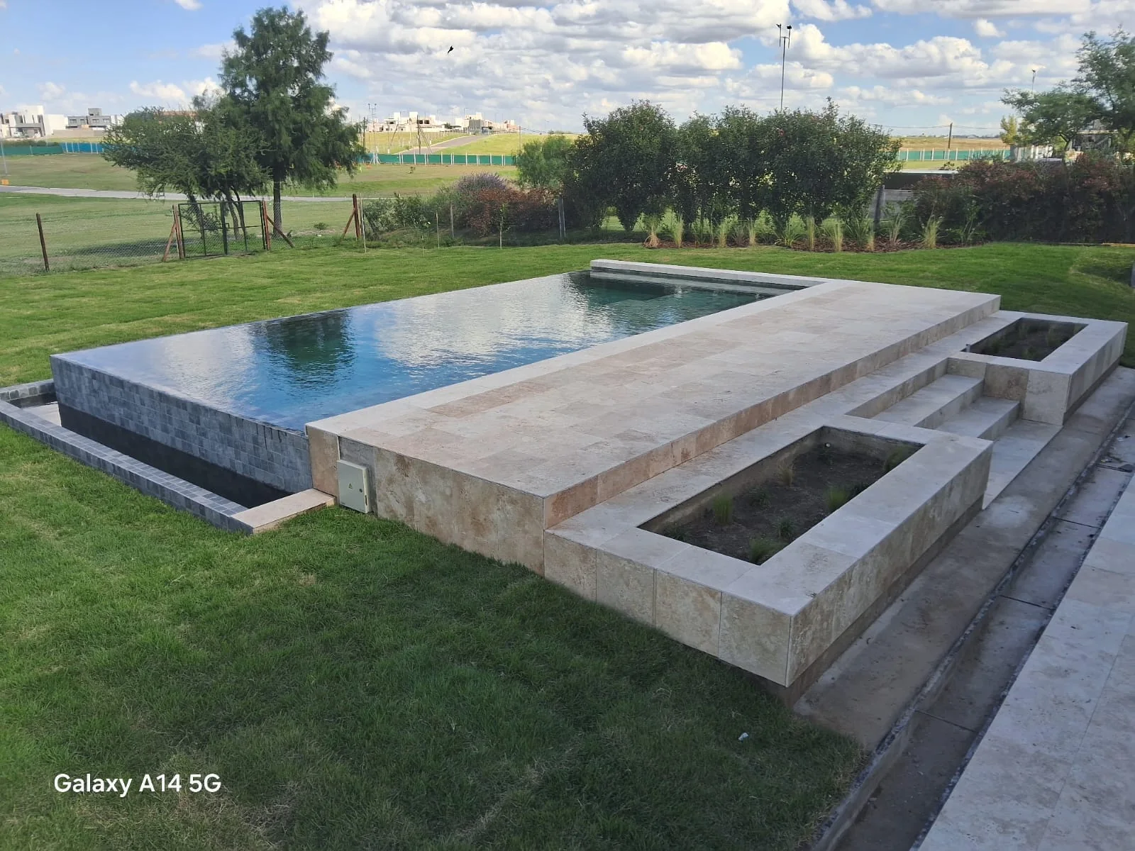 Piscina de material AquaLuxe integrada a un jardín residencial